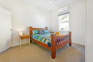 - une chambre avec un lit en bois et une fenêtre dans l'établissement Cottage on Lords, à Orange