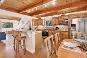 una cocina con armarios de madera y una mesa con sillas. en 2010-Lassen Paradise home, en Big Bear Lake