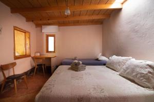 ein Schlafzimmer mit einem großen Bett und einem Tisch in der Unterkunft Hotel-Camping Takha Takha in San Pedro de Atacama