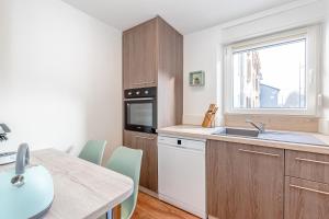 eine Küche mit Holzschränken, einer Spüle und einem Tisch in der Unterkunft La Maison Bohème - Proche Thionville, Metz, Luxembourg in Serémange-Erzange + 20 Fotos