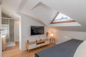 ein Schlafzimmer mit einem Bett und einem Fernseher an der Wand in der Unterkunft La Maison Bohème - Proche Thionville, Metz, Luxembourg in Serémange-Erzange