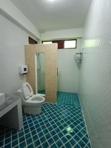 a bathroom with a toilet and a shower with blue tiles at Bann Suan Maya in Mae Rim