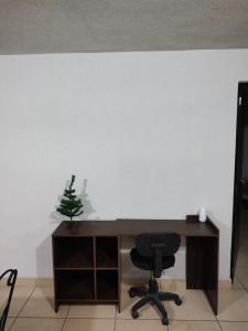 a desk with a chair and a christmas tree on it at Excelente Departamento céntrico. in Guadalajara