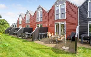 uma fila de casas com mesas e cadeiras num quintal em Lovely Home In Nrre Nebel With Wifi em Nørre Nebel