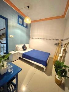 Un dormitorio con una cama azul y una mesa azul en Hi Hợp Yến Homestay, en Hoi An