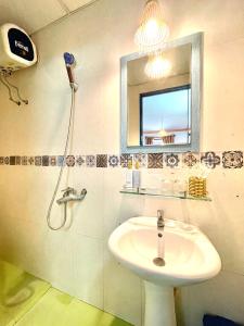 y baño con lavabo y espejo. en Hi Hợp Yến Homestay, en Hoi An