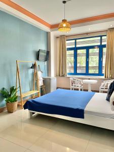 a bedroom with a large bed and a table at Hi Hợp Yến Homestay in Hoi An