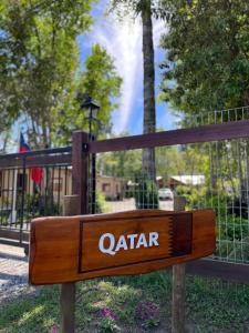 un panneau en bois devant une clôture dans l'établissement CABAÑAS QATAR PUCÓN, à Pucón