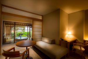 宮津市にあるホテル北野屋のソファ、テーブル、テーブル、窓が備わる客室です。