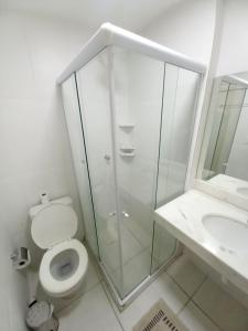 a bathroom with a shower and a toilet and a sink at Village Condomínio Porto Smeralda - Guarajuba in Guarajuba