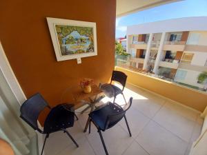 グアラジュバにあるVillage Condomínio Porto Smeralda - Guarajubaの椅子とテーブル、窓が備わる客室です。