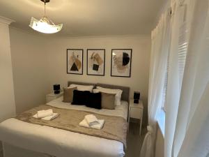 a bedroom with a bed with two towels on it at Stylish 1 Bedroom close to Tooting Bec Station in London