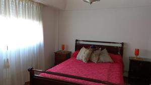 um quarto com uma cama com lençóis e almofadas cor-de-rosa em Departamento para vacacionar em Mar del Plata