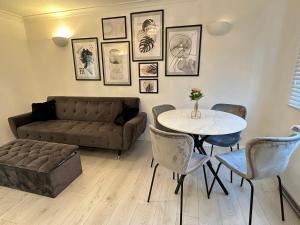 a living room with a couch and a table and chairs at Stylish 1 Bedroom close to Tooting Bec Station in London