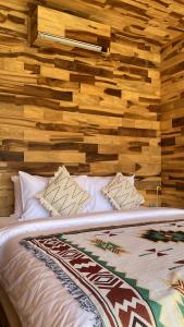 a bed in a room with a wooden wall at La Jempana Kintamani in Kintamani