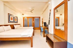Habitación de hotel con cama y espejo en Agos Boracay Rooms + Beds en Boracay