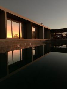einen Pool mit Sonnenuntergang im Hintergrund in der Unterkunft Lagoon Suites e Gastronomia in Laguna