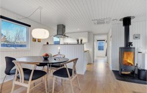 eine Küche und ein Esszimmer mit einem Tisch und einem Kamin in der Unterkunft Cozy Home In Pandrup With Kitchen in Pandrup