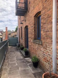 a brick building with a balcony and a patio at 1885 Warehouse Apartment in Tumbarumba