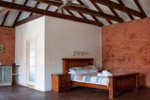 a bedroom with a bed and a brick wall at 1885 Warehouse Apartment in Tumbarumba