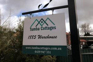 1885 Warehouse Apartment في Tumbarumba: علامة معلقة من عمود