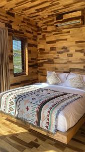 a large bed in a room with a wooden wall at La Jempana Kintamani in Kintamani