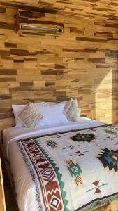 a bed in a room with a wooden wall at La Jempana Kintamani in Kintamani