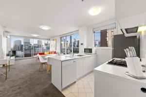 a kitchen and living room with views of the city at Exclusive Stays - Rivergarden in Melbourne