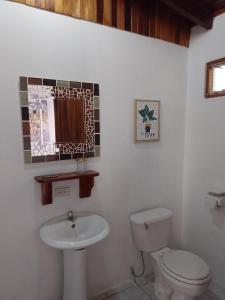 a bathroom with a toilet and a sink at Nasu Lodge in La Cruz
