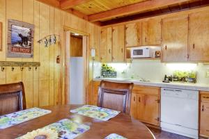 une cuisine avec des placards en bois et une table avec des chaises dans l'établissement 2095-Paradise in Cedar home, à Big Bear Lake