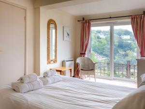 a bedroom with a bed and a large window at Estuary House Flat 3 in Salcombe