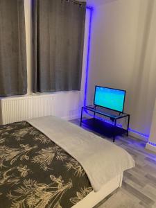 a bedroom with a bed and a laptop on a table at Cosy 1 Bedroom Apartment in London