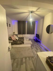 a living room with a couch and a ceiling at Cosy 1 Bedroom Apartment in London