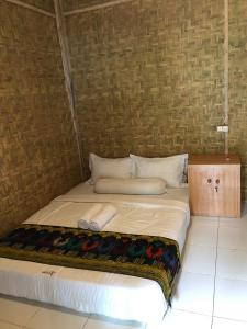 a large bed in a room with a wall at Azka Homestay in Kuta Lombok