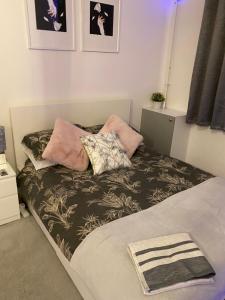 a bed with pillows on it in a bedroom at Cosy 1 Bedroom Apartment in London