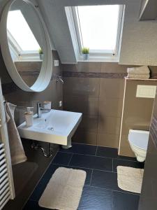a bathroom with a sink and a mirror and a toilet at 5Minuten von der City entfernte Wohnung mit Parkpl in Bielefeld