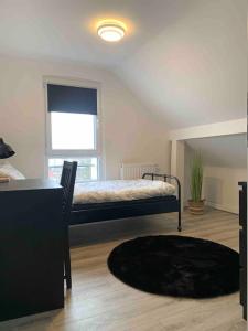 1 dormitorio con cama, mesa y alfombra en 5Minuten von der City entfernte Wohnung mit Parkpl, en Bielefeld