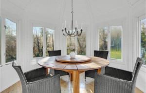 a dining room with a wooden table and chairs at Beautiful Home In Orø With Wifi in Orø