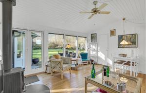 een woonkamer met een plafondventilator en een tafel bij Beautiful Home In Or With Wifi in Orø