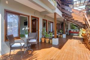 a patio with a table and chairs on a wooden floor at Nova Pousada dos Chás in Florianópolis