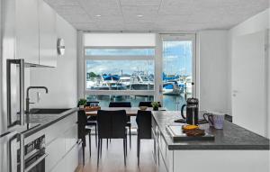 a kitchen with a table and a view of a marina at 2 Bedroom Lovely Ship In Grenaa in Grenå