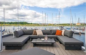 a couch on a dock with boats in the water at 2 Bedroom Lovely Ship In Grenaa in Grenå