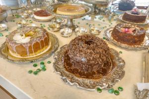 a table topped with cakes and other desserts on plates at Nova Pousada dos Chás in Florianópolis +92 photos