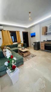 Luxury apartment Gueliz (2 min walk from Train Station) في مراكش: غرفة معيشة مع أريكة خضراء وطاولة