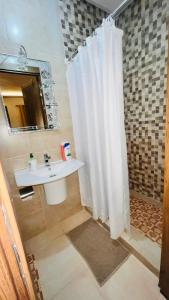 a bathroom with a white shower curtain and a sink at Luxury apartment Gueliz (2 min walk from Train Station) in Marrakech