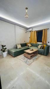 a living room with a green couch and a coffee table at Luxury apartment Gueliz (2 min walk from Train Station) in Marrakesh