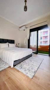 a bedroom with a large bed and a large window at Luxury apartment Gueliz (2 min walk from Train Station) in Marrakesh