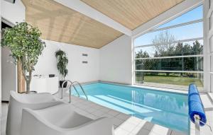 einen Pool in einem Haus mit einem großen Fenster in der Unterkunft Lovely Home In Vggerlse With Sauna in Bøtø By