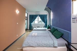 two beds in a room with blue walls at Knight Alley Hotel in Taiping