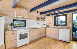 uma cozinha com electrodomésticos brancos e paredes de madeira em 3 Bedroom Awesome Home In Hjslev em Højslev